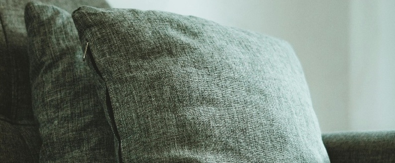 Close-up of acupuncture needles in a patient's back with hands of practitioner